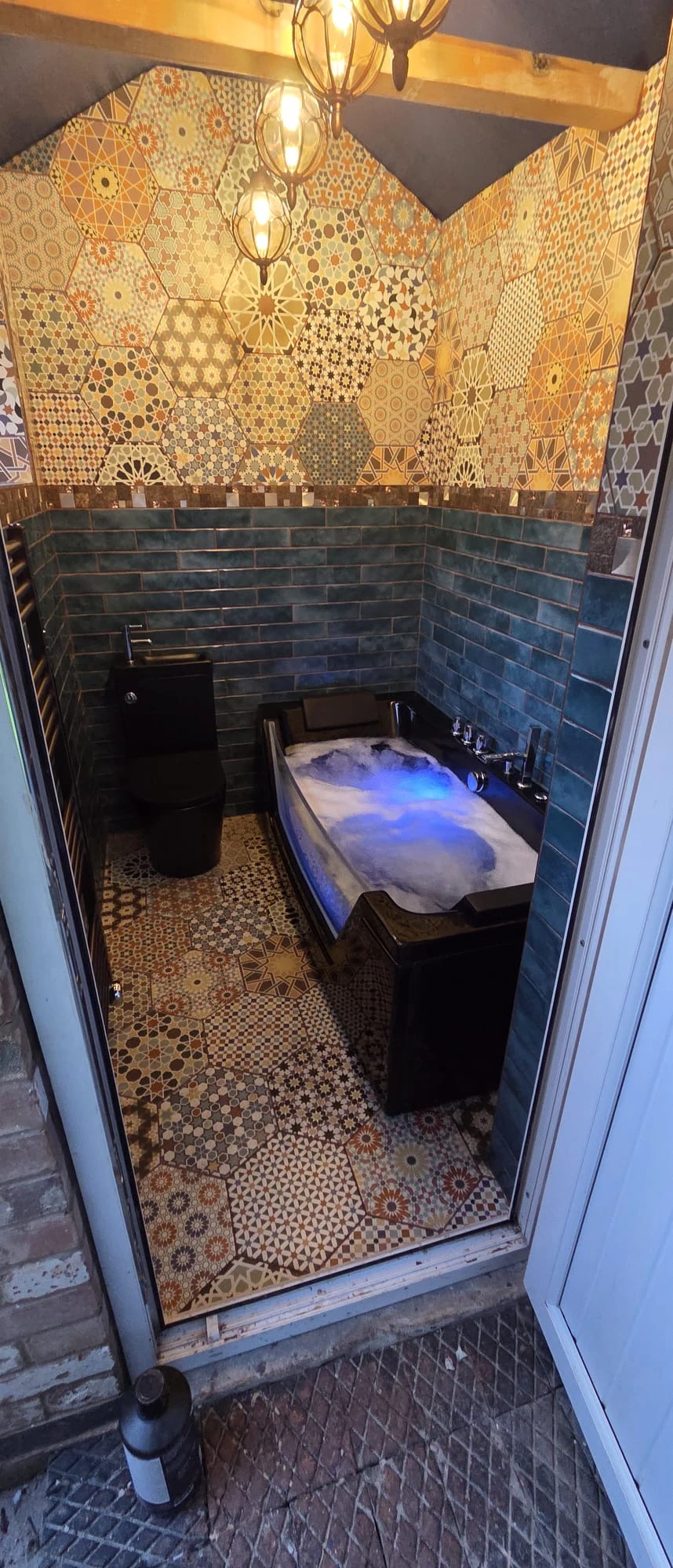 New bathroom fitted in Nottingham, featuring a black LED whirlpool jacuzzi bath, matching black WC and Moroccan hexagon floor tiles in Arnold