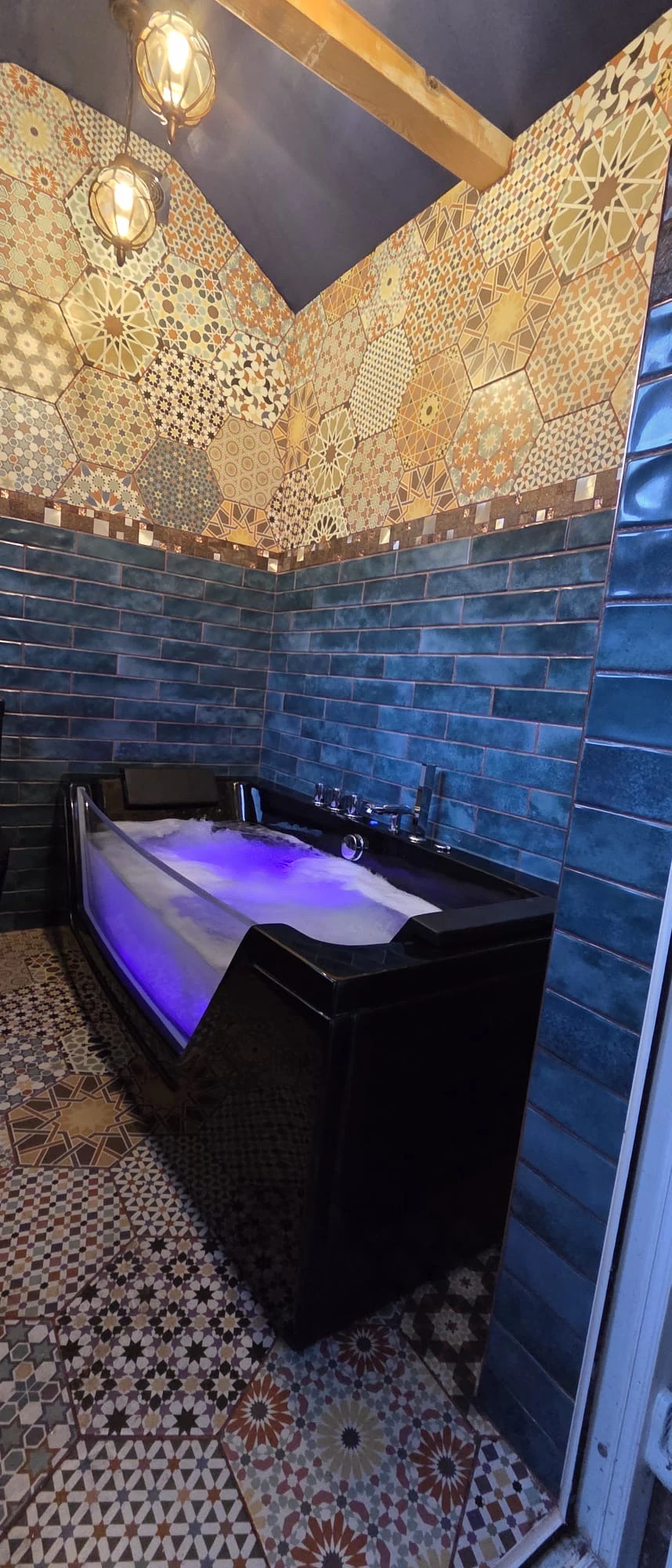 New bathroom with a black LED whirlpool bath, heated towel rail and pendant bathroom lighting over patterned Moroccan floor tiles, Arnold