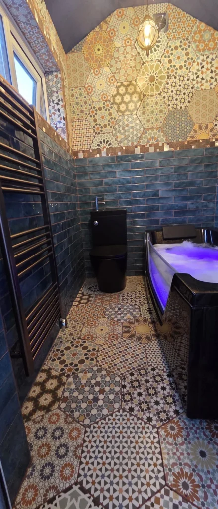 Bathroom lighting in Nottingham with an LED whirlpool bath glowing blue, blue metro wall tiles and Moroccan floor tiles, installed in Arnold, Nottingham.